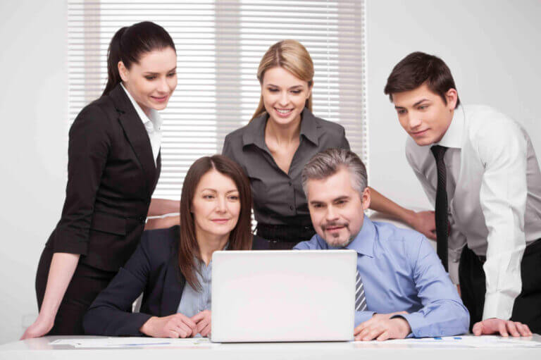 Large group of people looking together at laptop