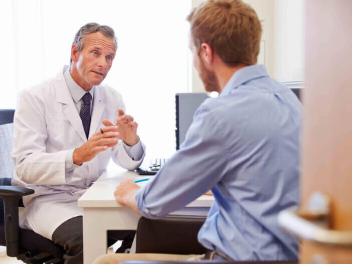 Male Patient Having Consultation With Doctor In Office