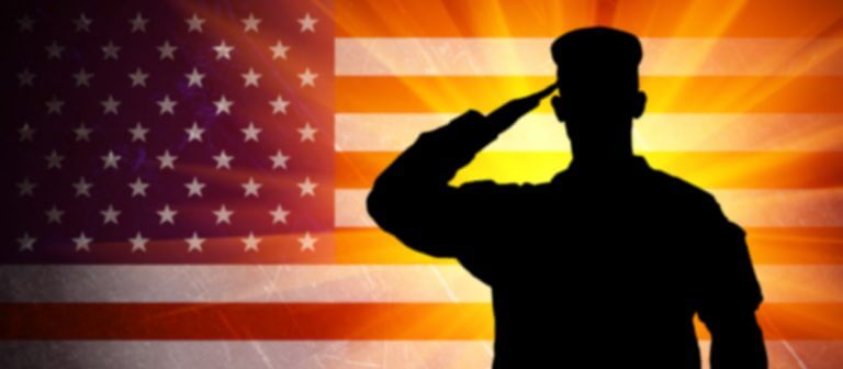military man saluting in front of an American flag