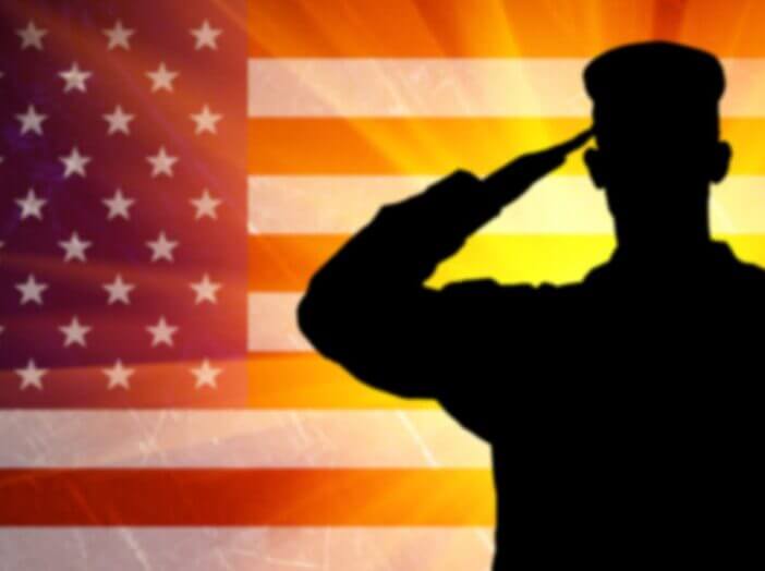 military man saluting in front of an American flag