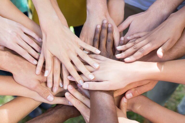 group of people with hands in the middle