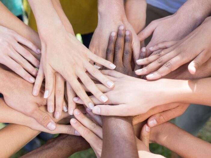 group of people with hands in the middle