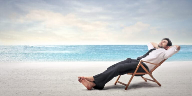 man in suit on a wood chair on the beach