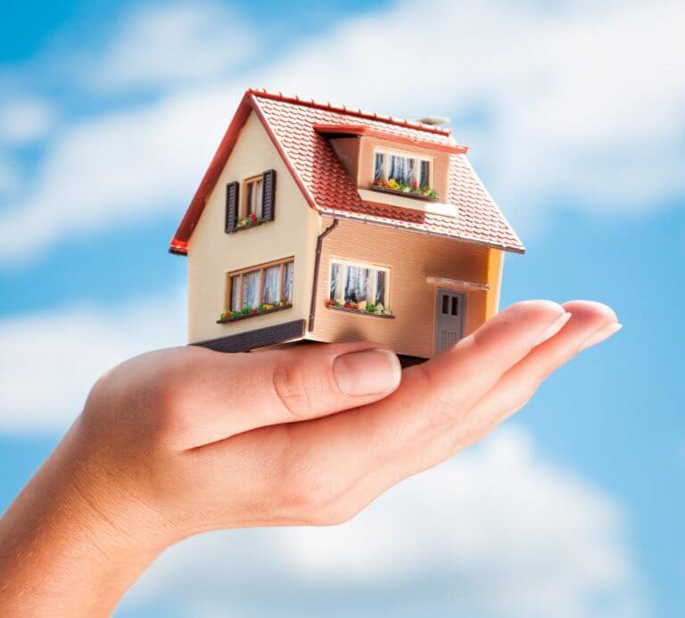 hand with small house figure in it