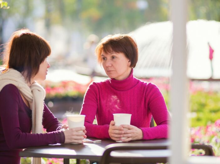 mom and daughter at coffee shop sadly talking