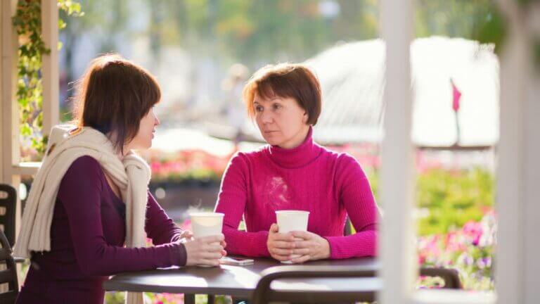 mom and daughter at coffee shop sadly talking