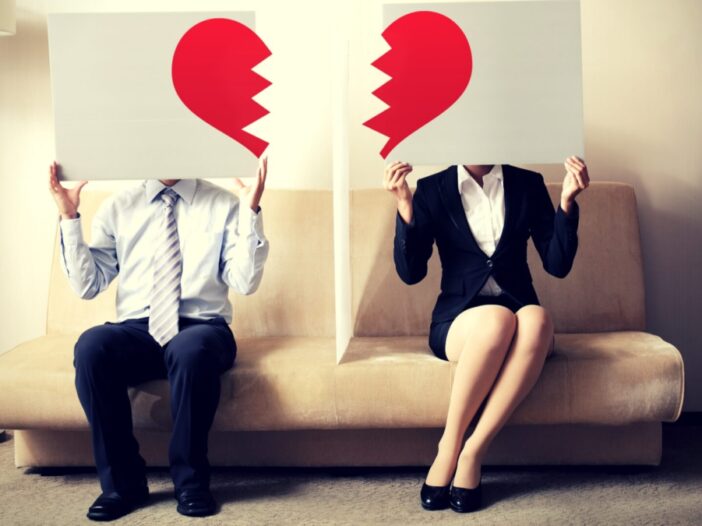 two people holding signs with broken heart