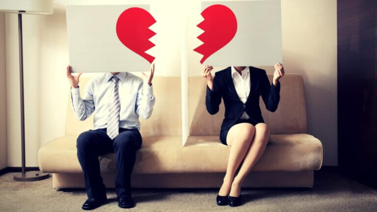 two people holding signs with broken heart