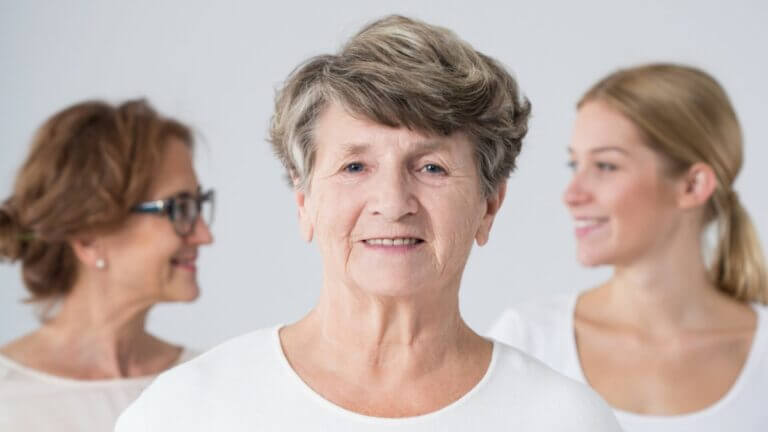 Elder woman with daughter and grand daughter out of focus in the background