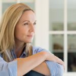 women with arms crossed gazing out to the right