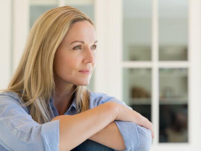 women with arms crossed gazing out to the right