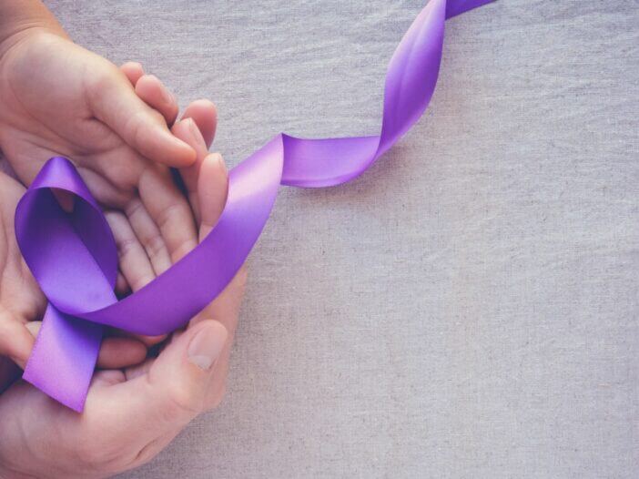 Alzheimers purple ribbon in hands of child and adult