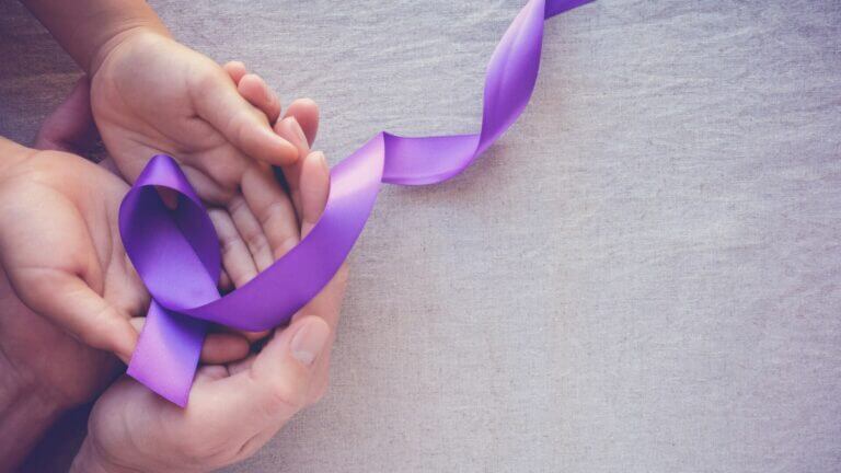 Alzheimers purple ribbon in hands of child and adult
