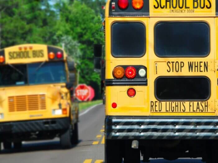 two school busses driving