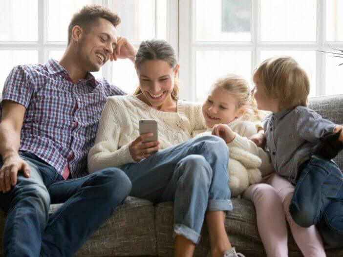 parents and young children on couch together