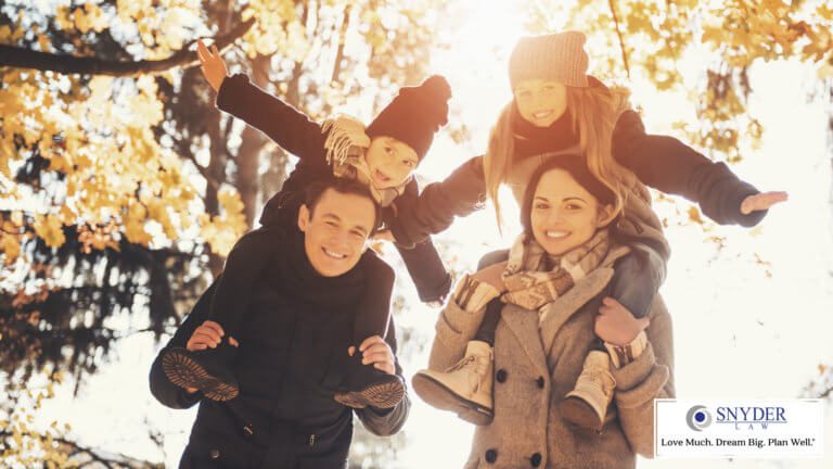parents with kids on their shoulders enjoy the outdoors in fall