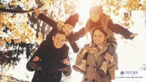 parents with kids on their shoulders enjoy the outdoors in fall