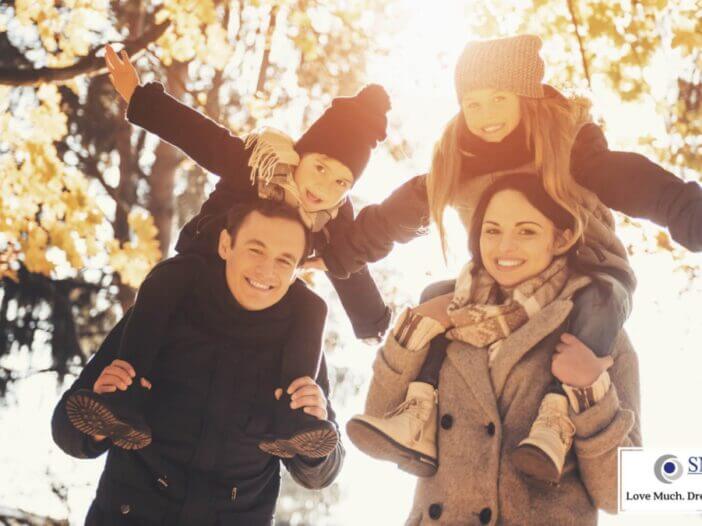 parents with kids on their shoulders enjoy the outdoors in fall