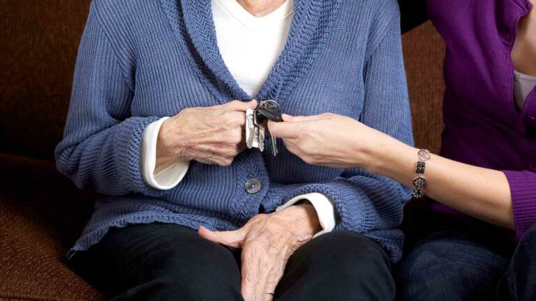 adult child takes keys away from elder mother