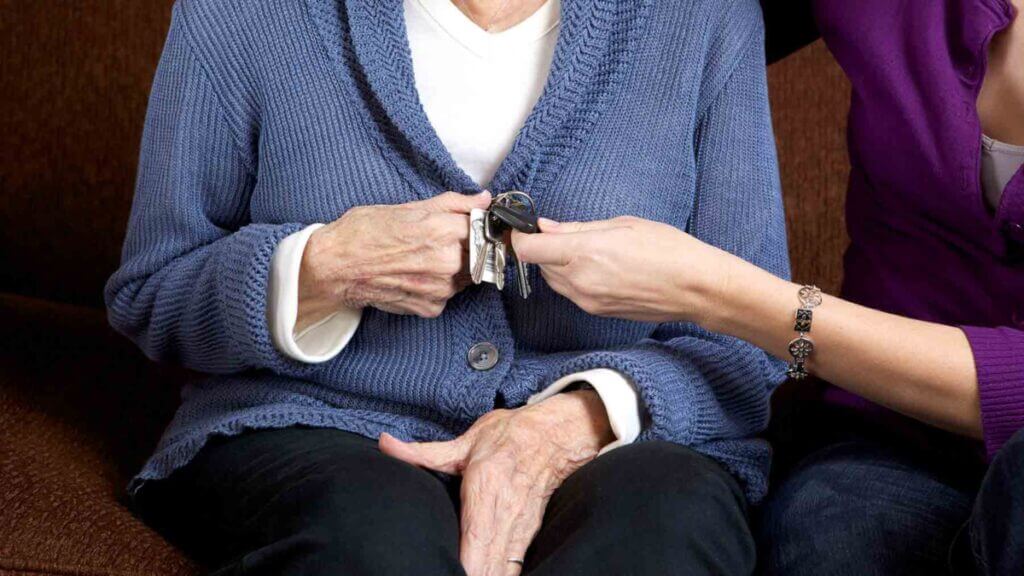 adult child takes keys away from elder mother