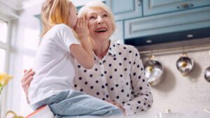 grandchild whispers in the ear of grandmother