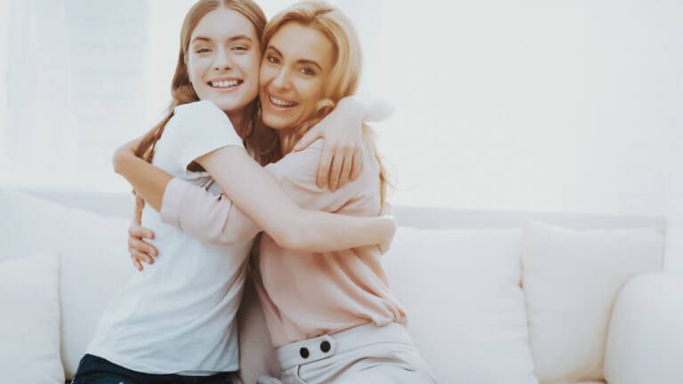 two women who look like sisters embrace and smile