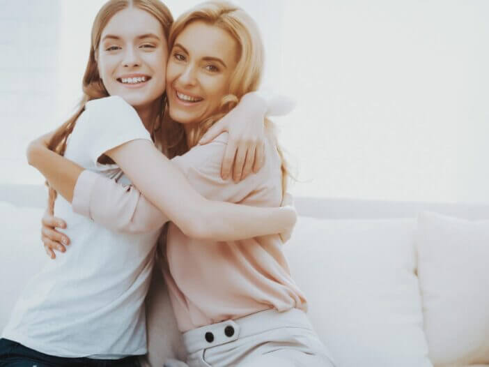 two women who look like sisters embrace and smile