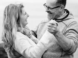 Middle aged couple dances and smiles