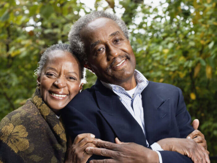 Senior couple smile and lean against each other