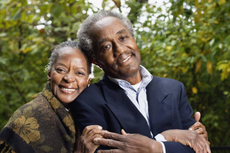 Senior couple smile and lean against each other