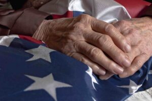 Elder person's hands holding an American flag