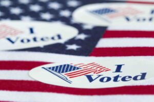'I Voted' stickers on the US flag background.