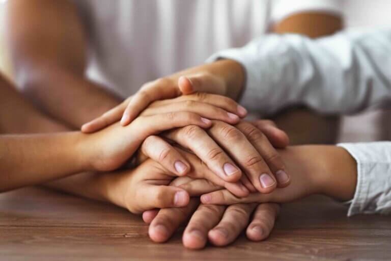 family hold hands together at the table