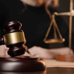 lawyer working with contract papers and wooden gavel on table in courtroom