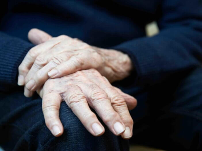 Close Up Of Senior Man Suffering With Parkinson’s Disease