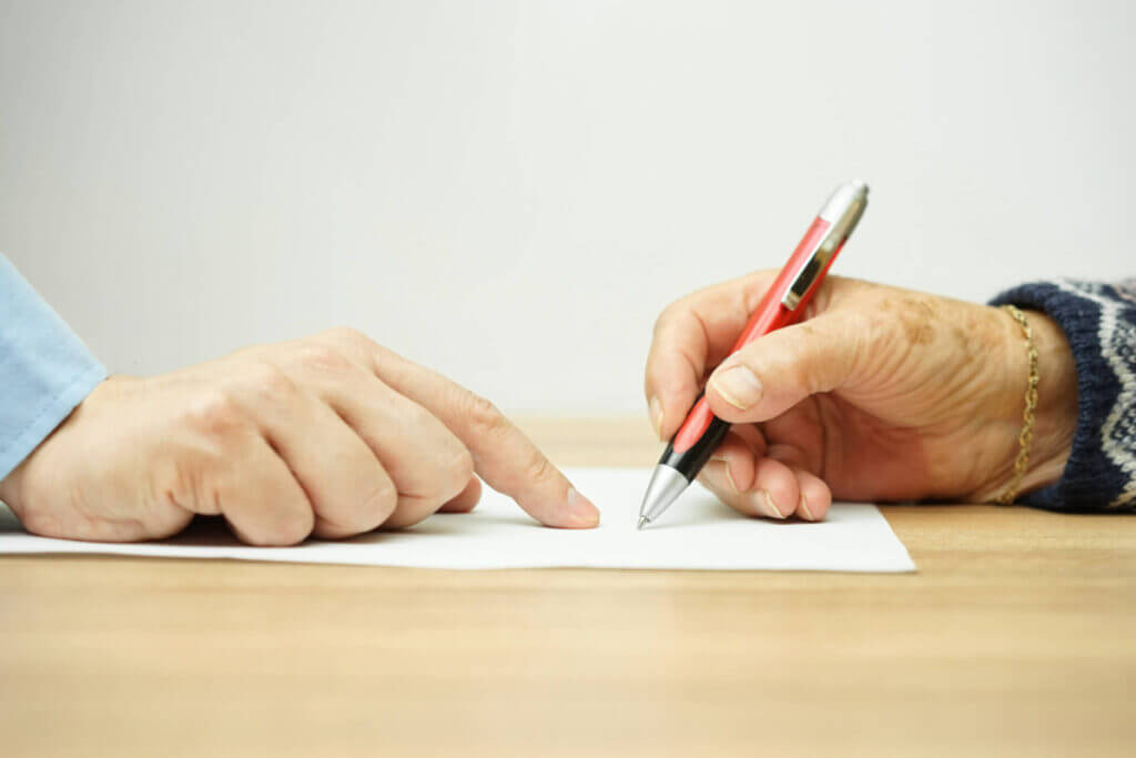 businessman man is pointing senior where to sign contract