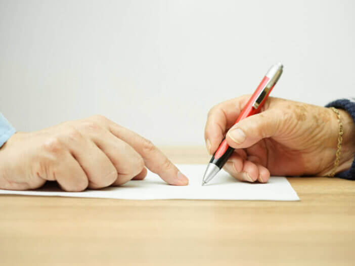 businessman man is pointing senior where to sign contract