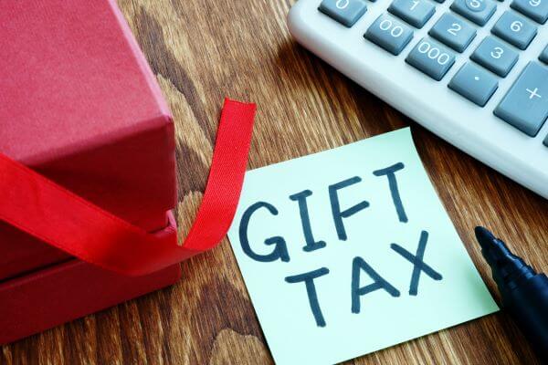 Post it note with "Gift Tax" written on it between calculator and gift