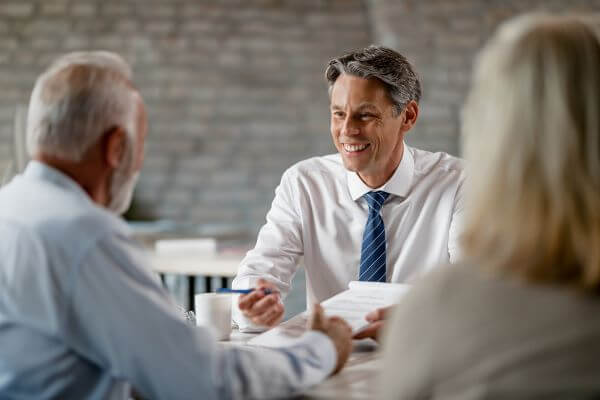 Estate Planning Attorney smiles across table from clients