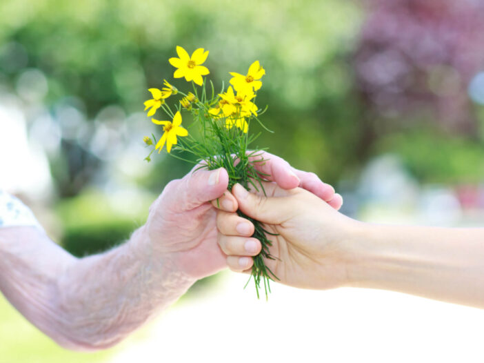 handing flowers to an elderly person