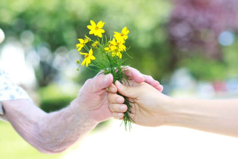 handing flowers to an elderly person