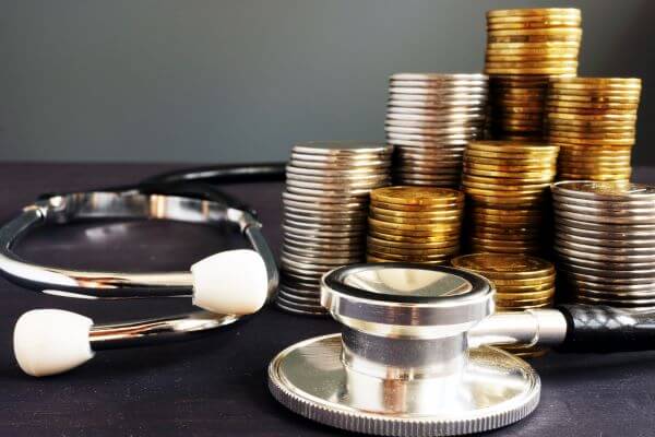 stacks of coins and a stethoscope