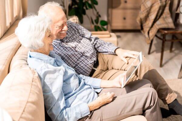 Senior couple looking at tablet on couch together
