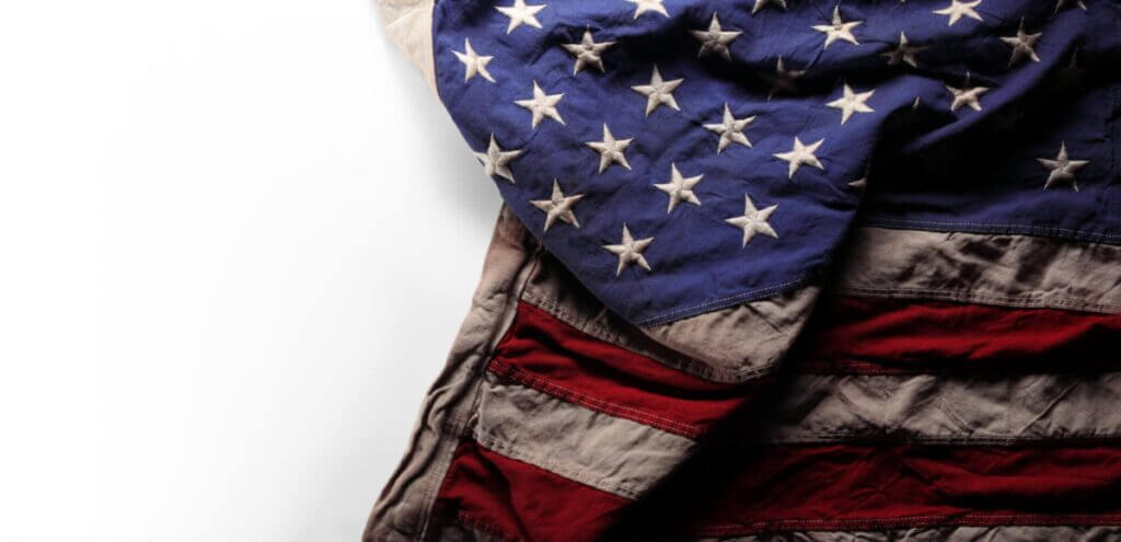 Wrinkled, aged, and worn US American flag with with blank white
