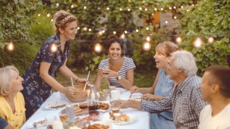 family sitting at a dinner table eating outside