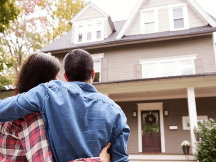 couple looking at front of house