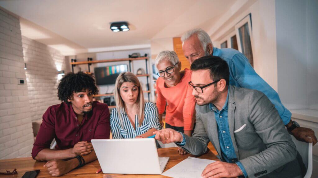 group of people looking at a laptop screen