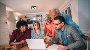group of people looking at a laptop screen