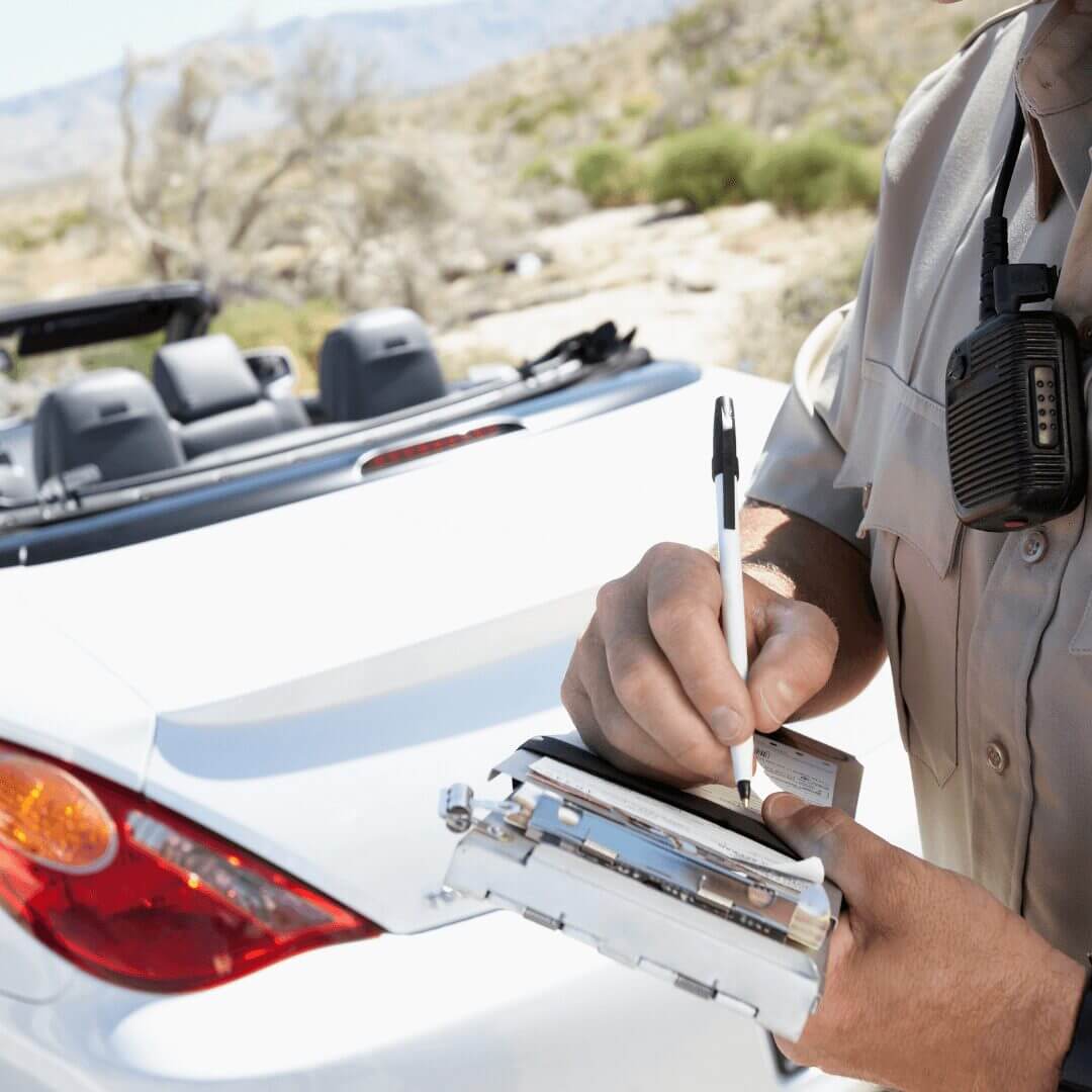 white car with police officer getting a traffic ticket