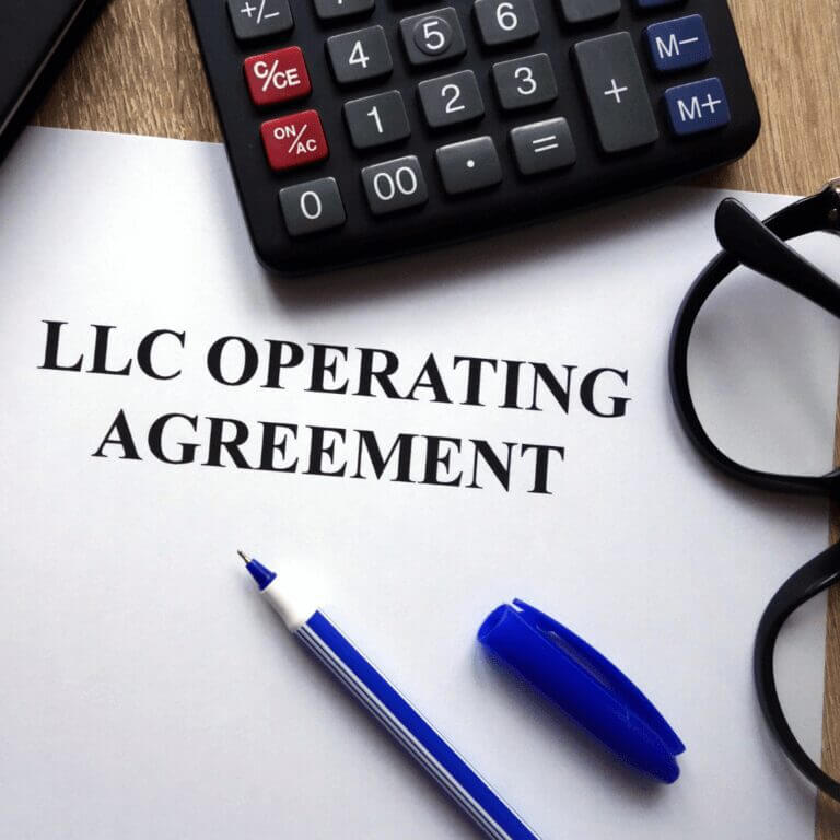 LLC operating agreement paper with glasses and pen
